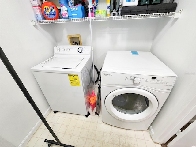 washroom featuring laundry area, washer and clothes dryer, and baseboards