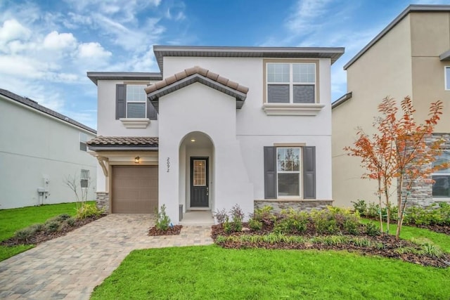 mediterranean / spanish-style home with a front lawn and a garage