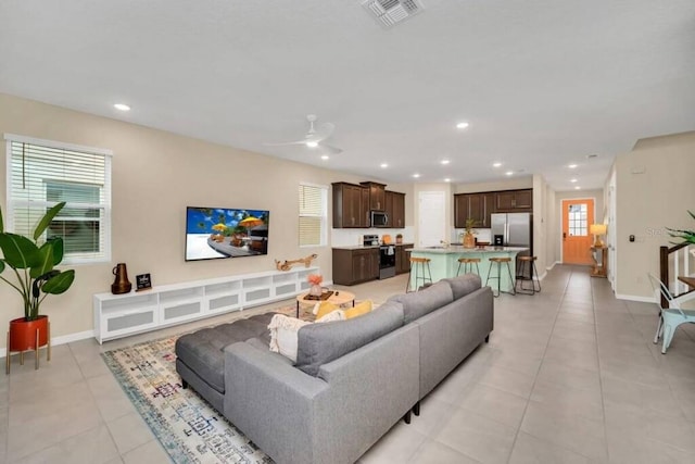 living room with light tile floors and ceiling fan