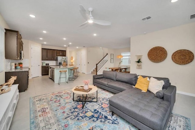 living room featuring light tile floors and ceiling fan