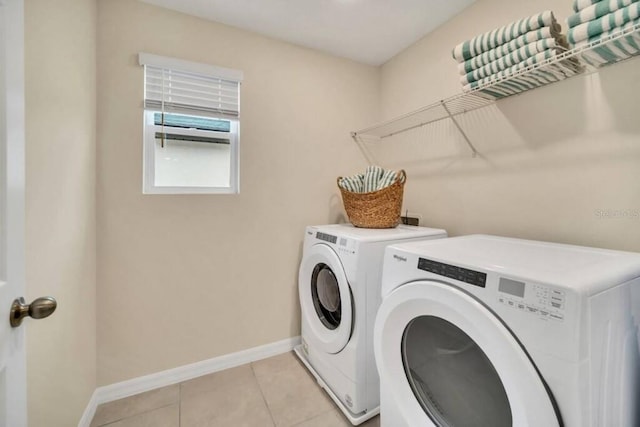 laundry area featuring washing machine and clothes dryer and light tile flooring