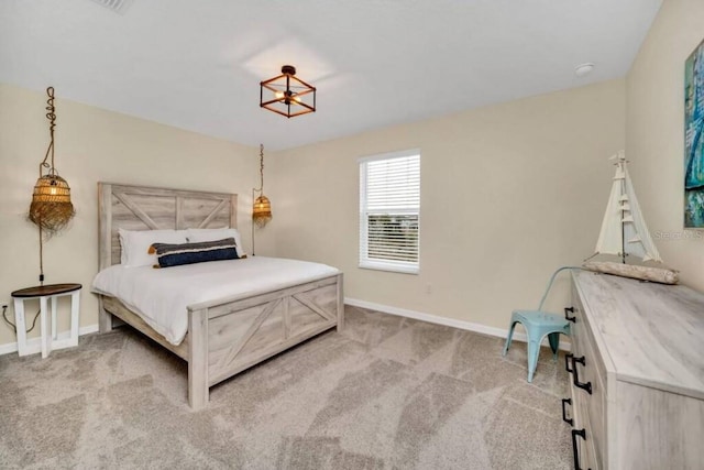 bedroom with a chandelier and light colored carpet