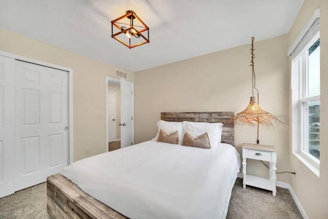 carpeted bedroom featuring a closet and a notable chandelier