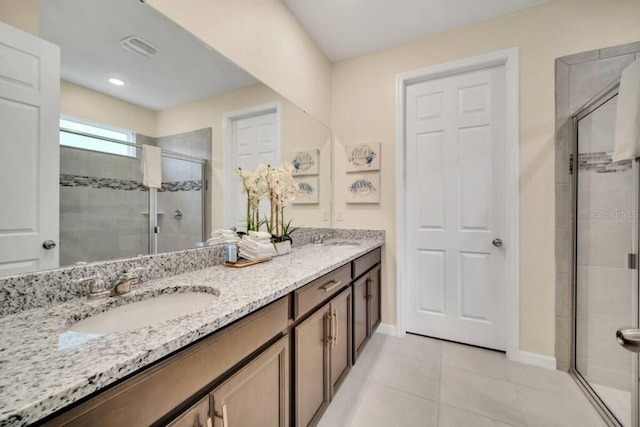 bathroom featuring an enclosed shower, tile flooring, and double vanity