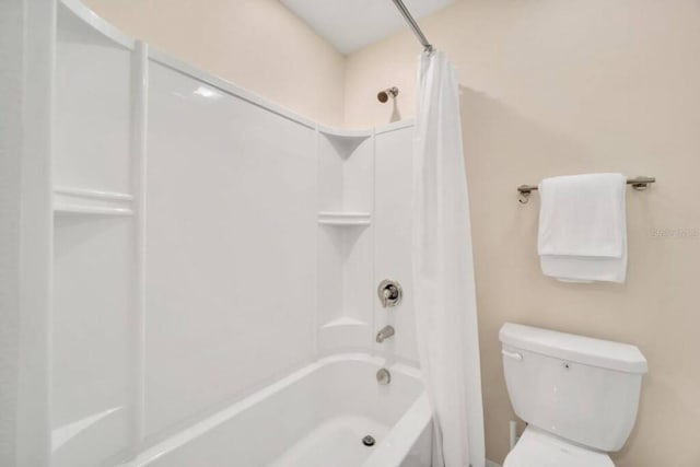 bathroom featuring shower / bath combination with curtain and toilet