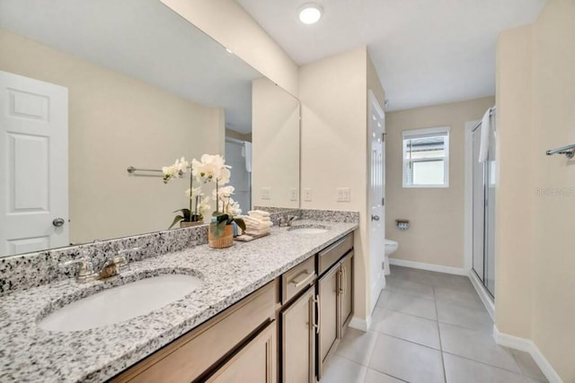 bathroom with toilet, double sink, large vanity, and tile flooring