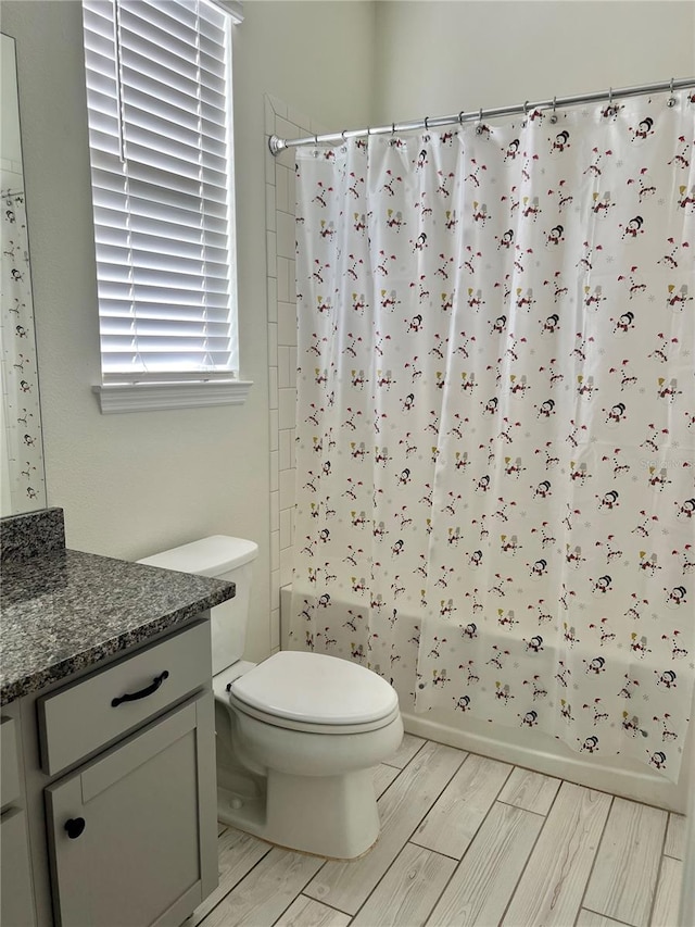 full bathroom with vanity, shower / bathtub combination with curtain, and toilet