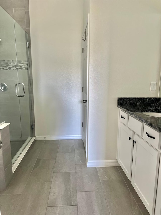 bathroom with vanity and a shower with shower door