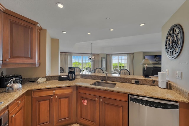 kitchen with kitchen peninsula, sink, stainless steel dishwasher, light stone countertops, and an inviting chandelier