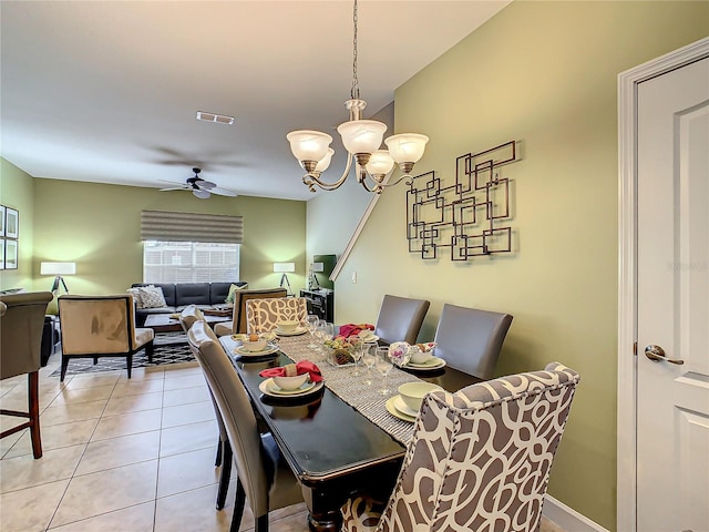 tiled dining room with ceiling fan with notable chandelier