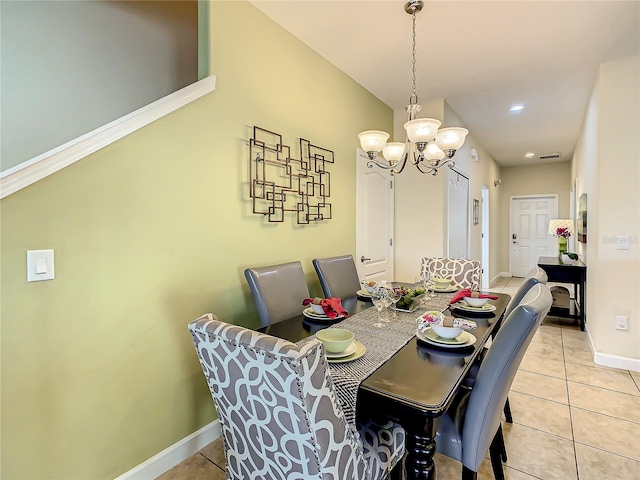 dining area with a chandelier and light tile flooring