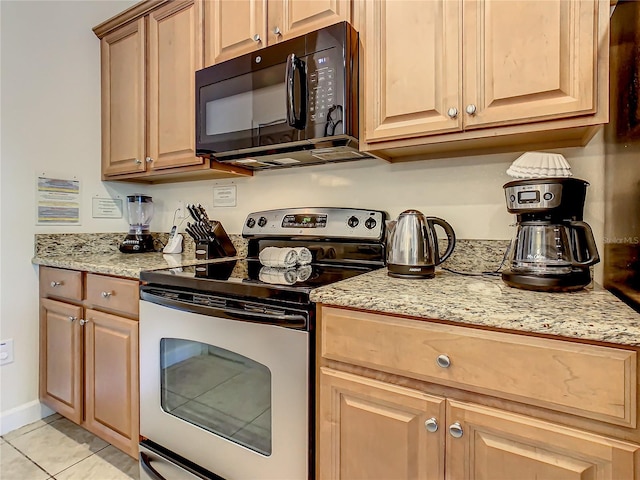 kitchen featuring light stone counters, electric range, and light tile flooring