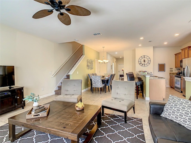 living room with light tile floors and ceiling fan with notable chandelier