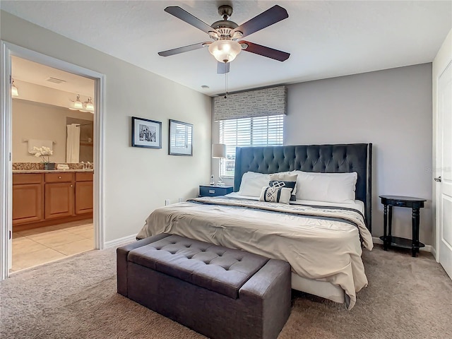 carpeted bedroom with ensuite bathroom and ceiling fan