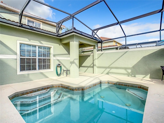 view of pool featuring a jacuzzi and glass enclosure