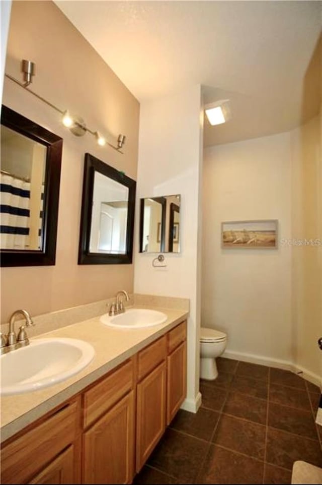 bathroom featuring tile patterned floors, vanity, and toilet