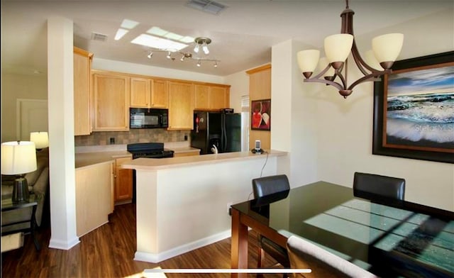 kitchen featuring kitchen peninsula, decorative light fixtures, a notable chandelier, and black appliances