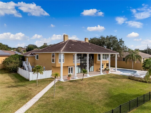 rear view of house featuring stucco siding, a patio, and a fenced backyard