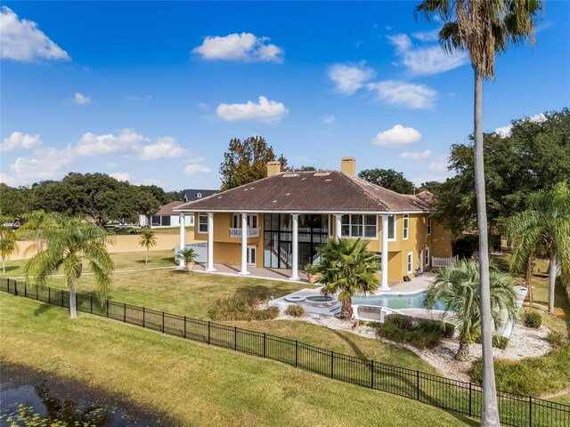 rear view of property featuring a yard, a fenced backyard, a chimney, and a patio area