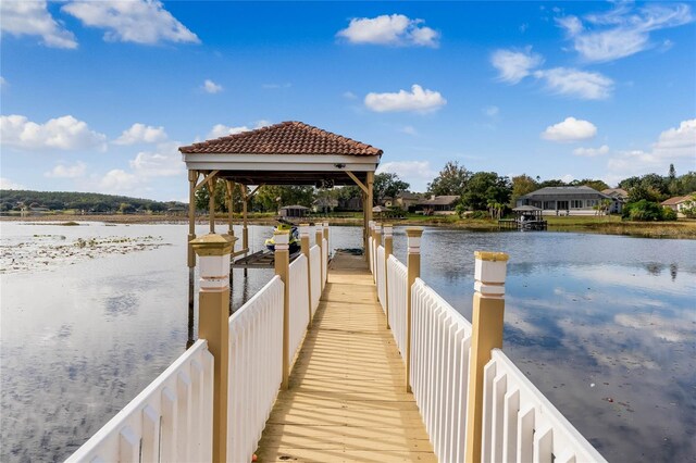 view of dock with a gazebo and a water view