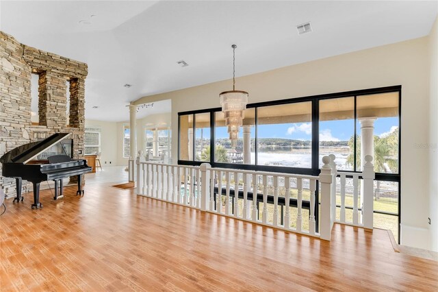 living room with wood finished floors, visible vents, and a chandelier