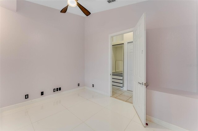 interior space with ceiling fan, visible vents, baseboards, and light tile patterned flooring