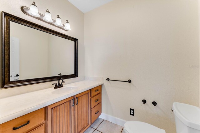 bathroom with vanity, tile patterned floors, toilet, and baseboards