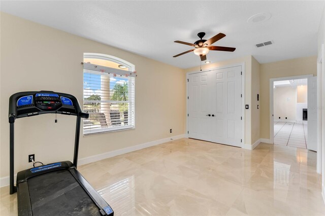 exercise area with a ceiling fan, baseboards, and visible vents