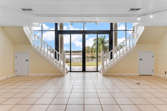 interior space with stairs, light tile patterned floors, and visible vents