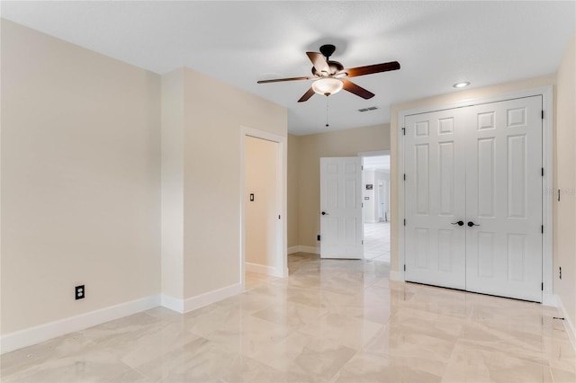 empty room with visible vents, baseboards, marble finish floor, and ceiling fan