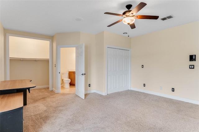 unfurnished bedroom featuring light carpet, visible vents, baseboards, and a closet