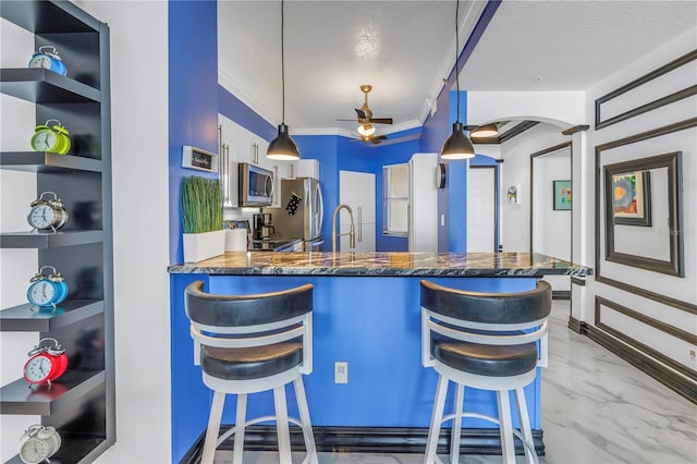 kitchen with hanging light fixtures, a peninsula, a breakfast bar area, and open shelves