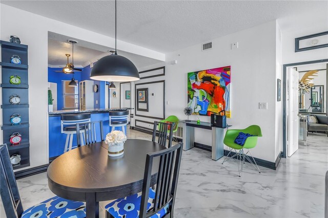 dining area featuring marble finish floor, visible vents, baseboards, and a textured ceiling