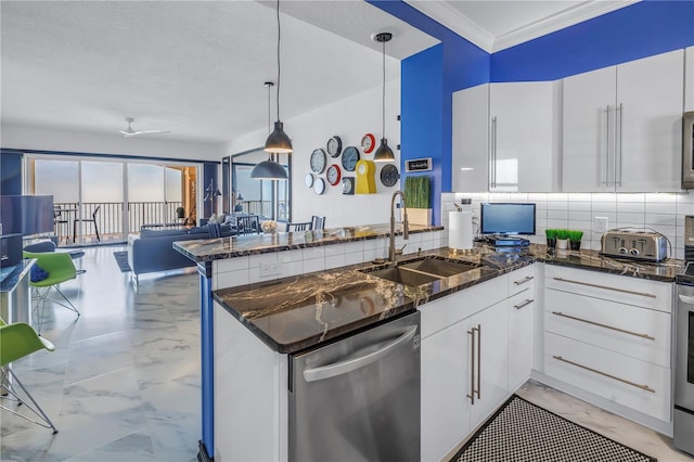 kitchen with pendant lighting, white cabinets, a sink, and stainless steel dishwasher