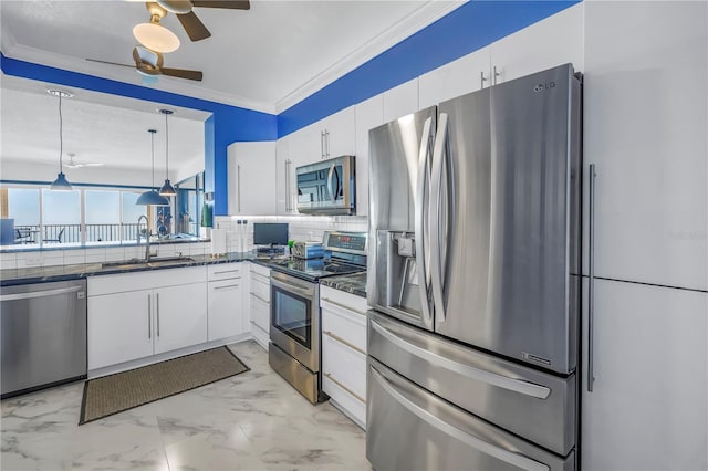 kitchen with white cabinets, appliances with stainless steel finishes, decorative light fixtures, a sink, and backsplash