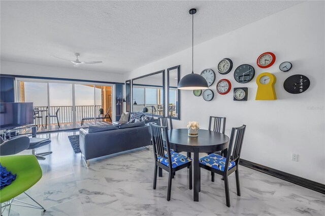 dining room with a textured ceiling, marble finish floor, a ceiling fan, and baseboards