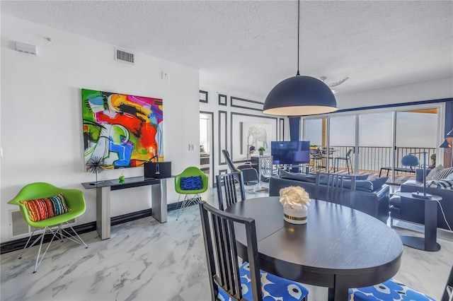 dining space with marble finish floor, visible vents, and a textured ceiling