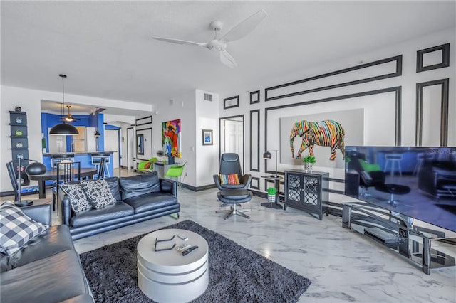 living area with a ceiling fan, marble finish floor, visible vents, and baseboards