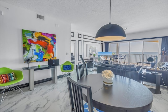 dining space with marble finish floor, baseboards, visible vents, and a textured ceiling