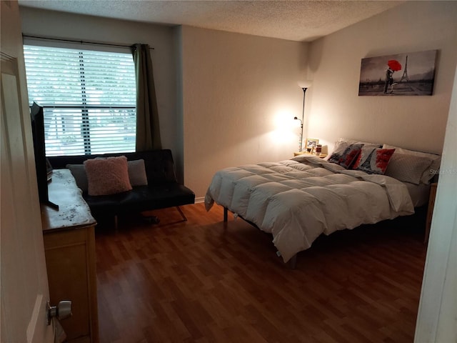 bedroom featuring a textured ceiling and dark wood-type flooring