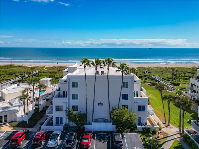 birds eye view of property with a water view and a beach view