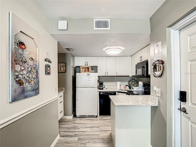 kitchen featuring sink, light stone counters, light hardwood / wood-style flooring, black appliances, and white cabinetry