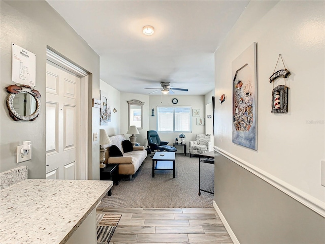 living room featuring light hardwood / wood-style floors and ceiling fan