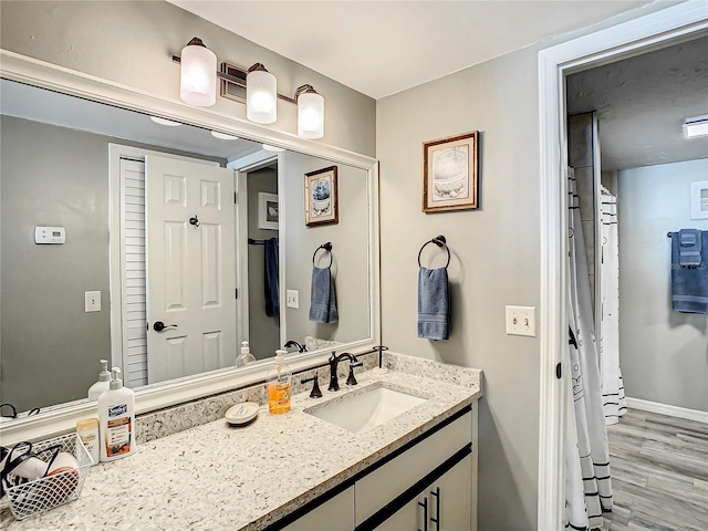 bathroom with vanity with extensive cabinet space and hardwood / wood-style floors