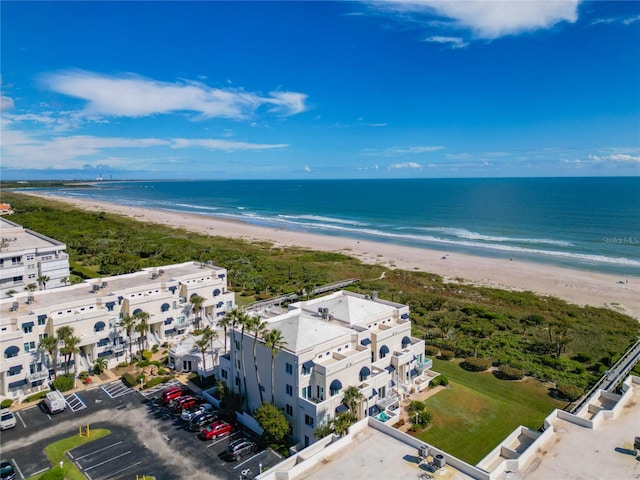 drone / aerial view with a water view and a beach view