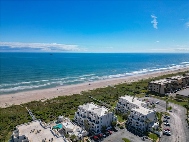 birds eye view of property featuring a water view and a beach view