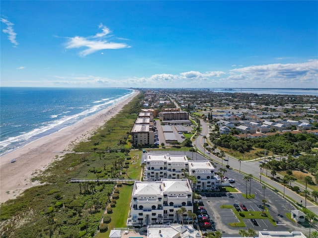 drone / aerial view featuring a water view and a view of the beach