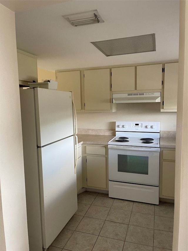 kitchen featuring light countertops, white appliances, light tile patterned flooring, and under cabinet range hood