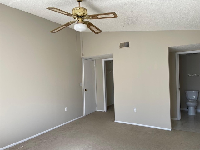 carpeted spare room featuring lofted ceiling and ceiling fan