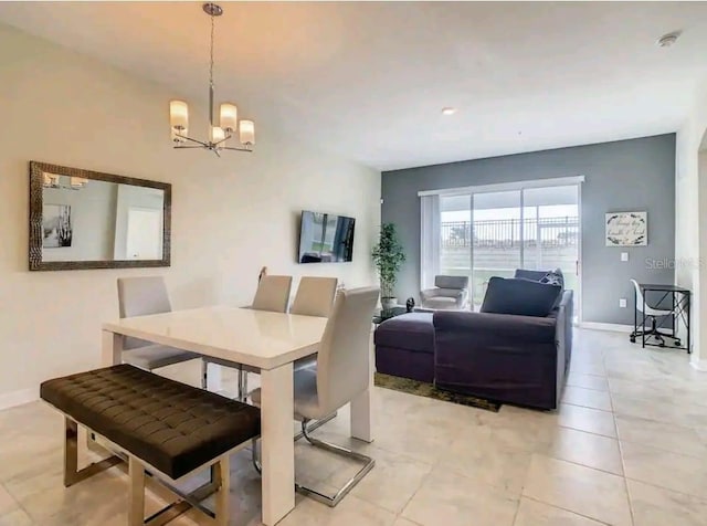 dining space with light tile floors and an inviting chandelier